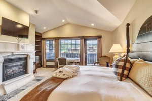 Carpeted bedroom featuring lofted ceiling and access to exterior