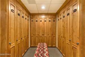 Mudroom featuring dark colored carpet and a paneled ceiling
