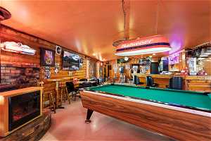 Recreation room with indoor bar, light tile flooring, and billiards