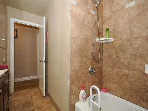 Bathroom with tile floors, vanity, and tiled shower / bath combo