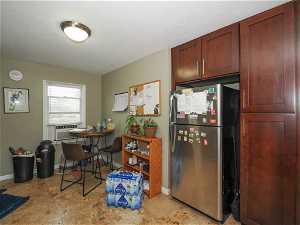 Kitchen featuring light tile flooring and stainless steel refrigerator