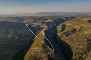 Aerial view of property's location featuring a mountain backdrop and property boundaries highlighted