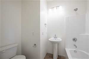 Bathroom featuring shower / bath combination, hardwood / wood-style flooring, and toilet