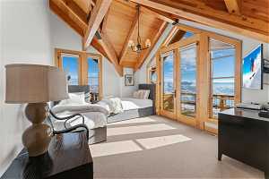 Carpeted bedroom featuring wood ceiling, access to exterior, a notable chandelier, and vaulted ceiling with beams