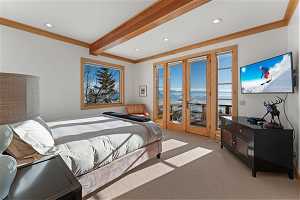 Carpeted bedroom with access to exterior, beamed ceiling, crown molding, and french doors