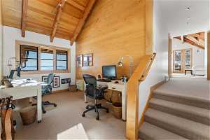 Carpeted office featuring wooden walls, high vaulted ceiling, beam ceiling, and wooden ceiling