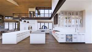 Kitchen featuring a kitchen island, white cabinetry, sink, and a towering ceiling