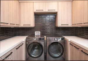 Laundry area with cabinets and washer and clothes dryer