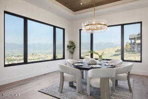 Dining room with a notable chandelier, a mountain view, hardwood / wood-style floors, and a tray ceiling