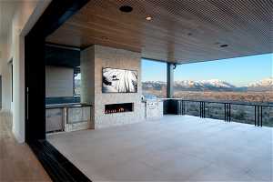 View of patio with grilling area, a mountain view, a balcony, and an outdoor kitchen