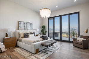 Bedroom featuring hardwood / wood-style flooring, a notable chandelier, and access to outside