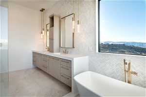 Bathroom featuring a tub, a mountain view, dual vanity, and tile flooring