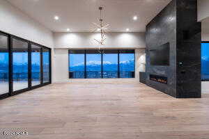 Unfurnished living room with a large fireplace, a mountain view, and hardwood / wood-style flooring