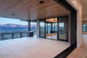 Snow covered patio featuring a balcony and a mountain view