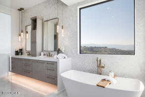 Bathroom with a tub, vanity, and tile walls