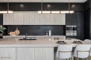 Kitchen featuring sink, stainless steel double oven, tasteful backsplash, and a kitchen breakfast bar