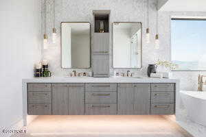 Bathroom featuring a washtub and double sink vanity