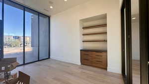 Unfurnished room with light hardwood / wood-style floors and floor to ceiling windows