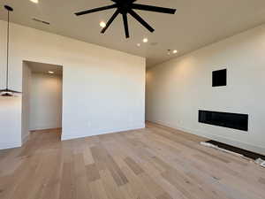 Unfurnished living room with ceiling fan and light hardwood / wood-style floors