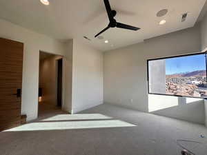 Carpeted spare room featuring ceiling fan