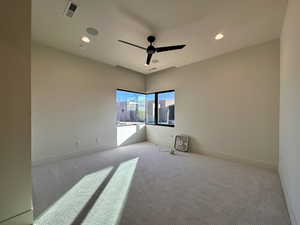 Carpeted spare room with ceiling fan