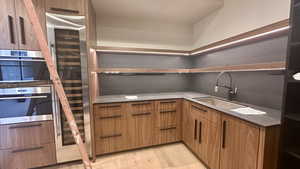 Kitchen with light wood-type flooring, sink, and double oven