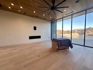 Interior space featuring light hardwood / wood-style floors, floor to ceiling windows, access to exterior, and wooden ceiling