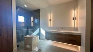 Bathroom featuring tile patterned floors, vanity, and tiled shower