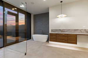 Bathroom featuring expansive windows, vanity, and a tub