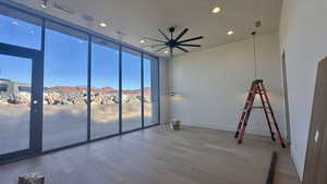 Spare room featuring a mountain view, hardwood / wood-style floors, and ceiling fan