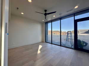 Empty room featuring light hardwood / wood-style floors, plenty of natural light, and floor to ceiling windows