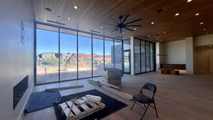 Living room with wood-type flooring, a wall of windows, and wood ceiling