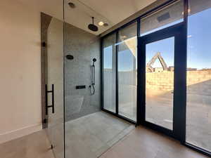 Bathroom featuring tile patterned floors, floor to ceiling windows, and a shower with door