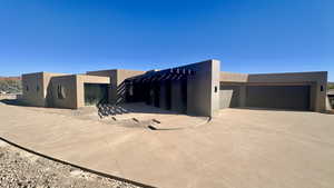 Pueblo revival-style home with a pergola and a garage