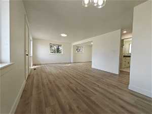 Unfurnished room featuring dark hardwood / wood-style flooring and a notable chandelier