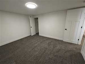 Unfurnished bedroom with dark carpet