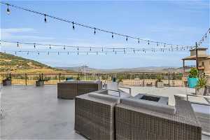 View of terrace with a mountain view and an outdoor living space with a fire pit