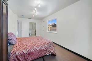 Bedroom featuring track lighting and carpet