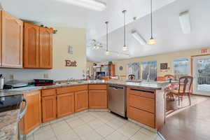 Kitchen with lofted ceiling, ceiling fan, decorative light fixtures, kitchen peninsula, and appliances with stainless steel finishes