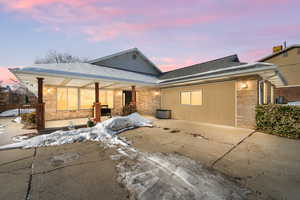 Snow covered rear of property featuring a patio