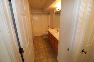 Full bathroom featuring large vanity,  shower combination, tile flooring, and toilet