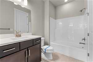 Full bathroom with tile floors, vanity, shower / tub combination, and toilet
