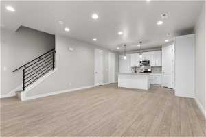 Unfurnished living room with light hardwood / wood-style flooring and sink