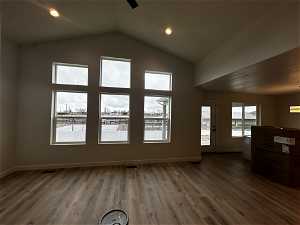 Spare room with dark hardwood / wood-style flooring and lofted ceiling