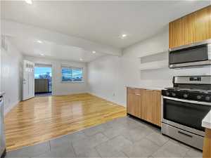Kitchen featuring light hardwood / wood-style floors, beamed ceiling, and stainless steel appliances