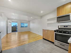 Kitchen featuring light hardwood / wood-style floors, beamed ceiling, and stainless steel appliances