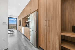 Kitchen featuring modern cabinets, appliances with stainless steel finishes, and dark wood-type flooring