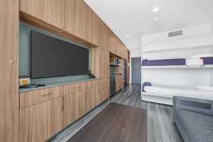 Living area with dark wood-type flooring and recessed lighting