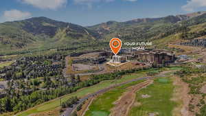 Aerial view of property and surrounding area featuring a mountainous background