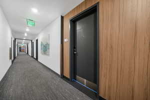 Corridor featuring recessed lighting and dark carpet
